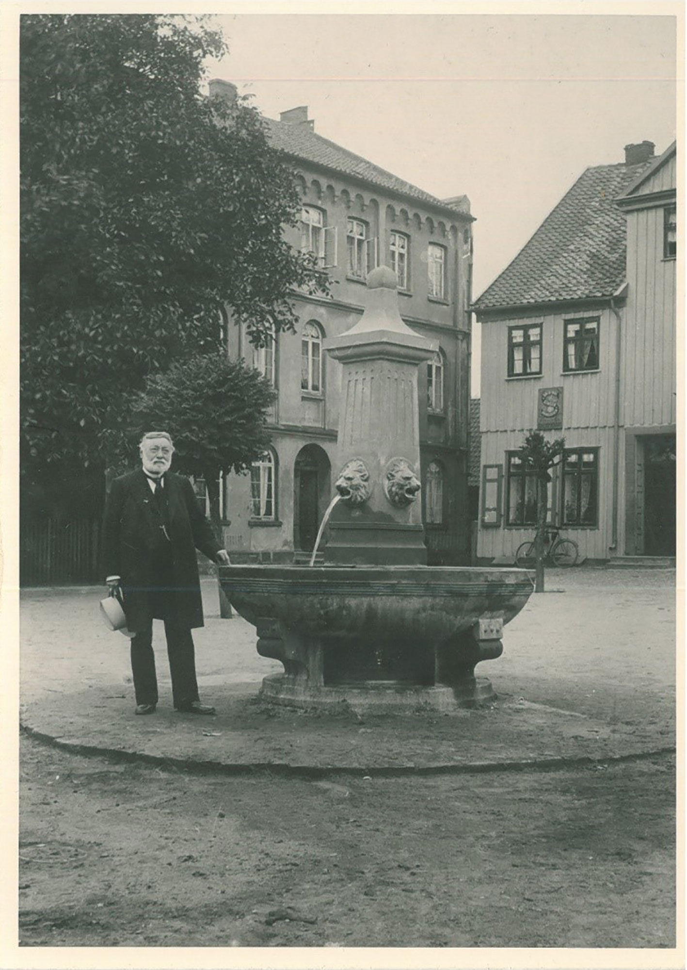 (c) Stadtarchiv Gifhorn, Bilderserie Gifhorn gestern und heute,F-01 - Senator Hermann Schulze neben dem nach ihm benannten Brunnen, 1904